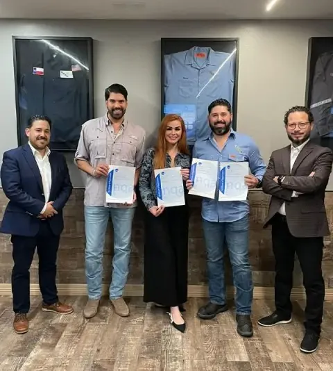 Profesionales posan, mostrando diplomas s, simbolizando su éxito en la capacitación para la implementación de normas ISO.