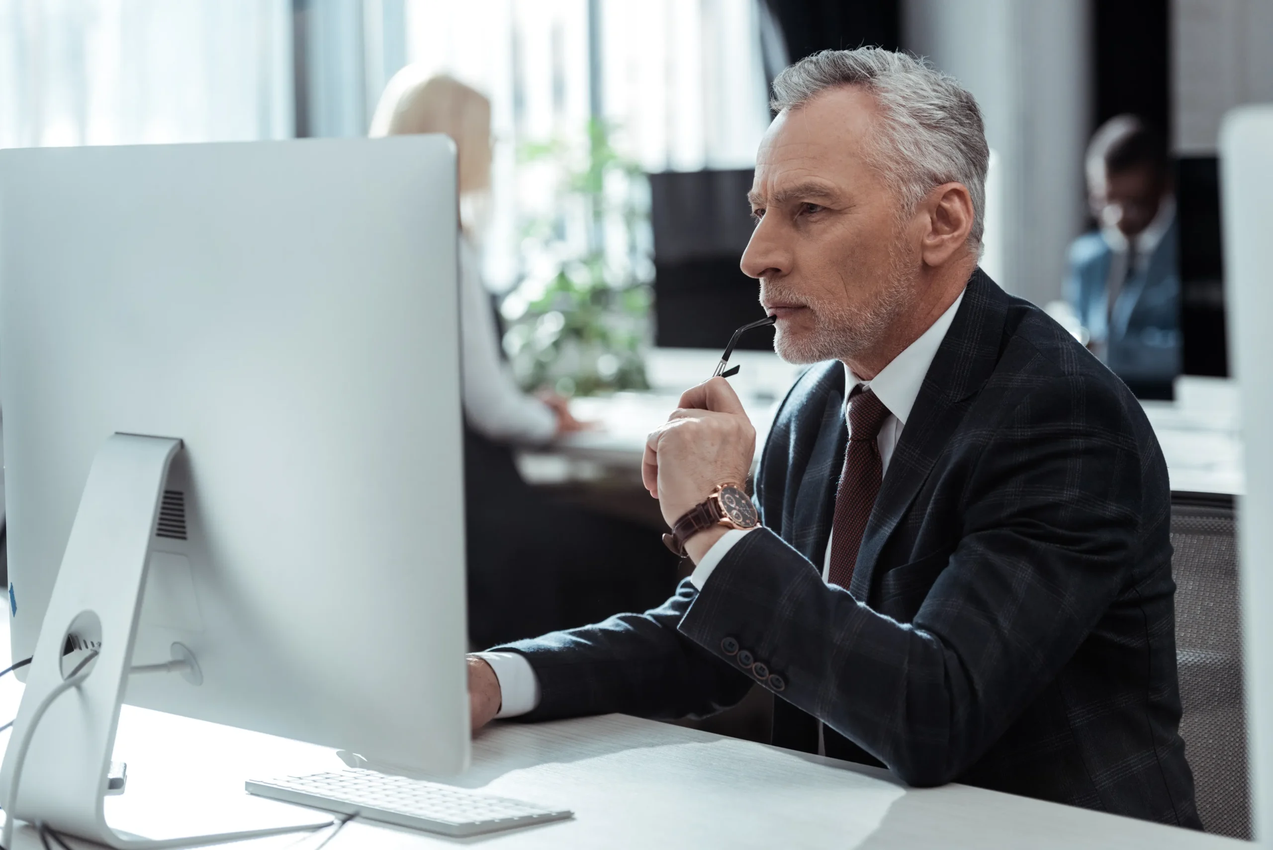Imagen de un jefe de empresa checando en su computadora cuánto cuesta la certificación ISO 9001 para una cotización