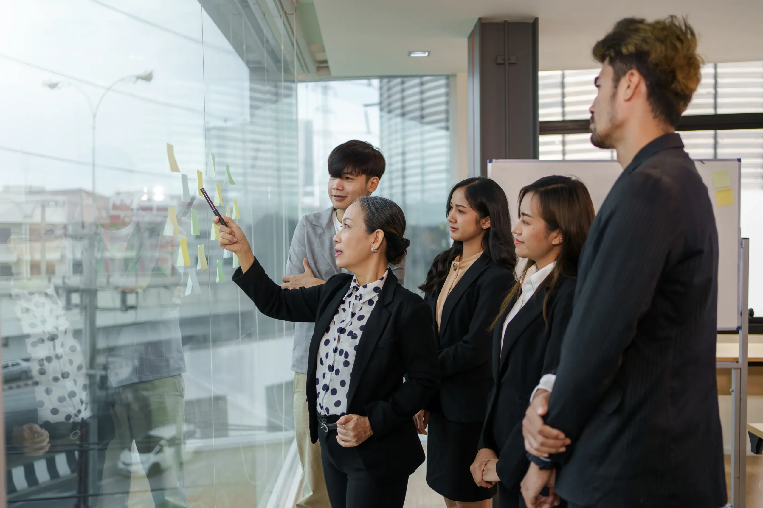 Fotográfia de un experto en gestión organizacional explicando a los colaboradores de una empresa cuál es el camino correcto a seguir