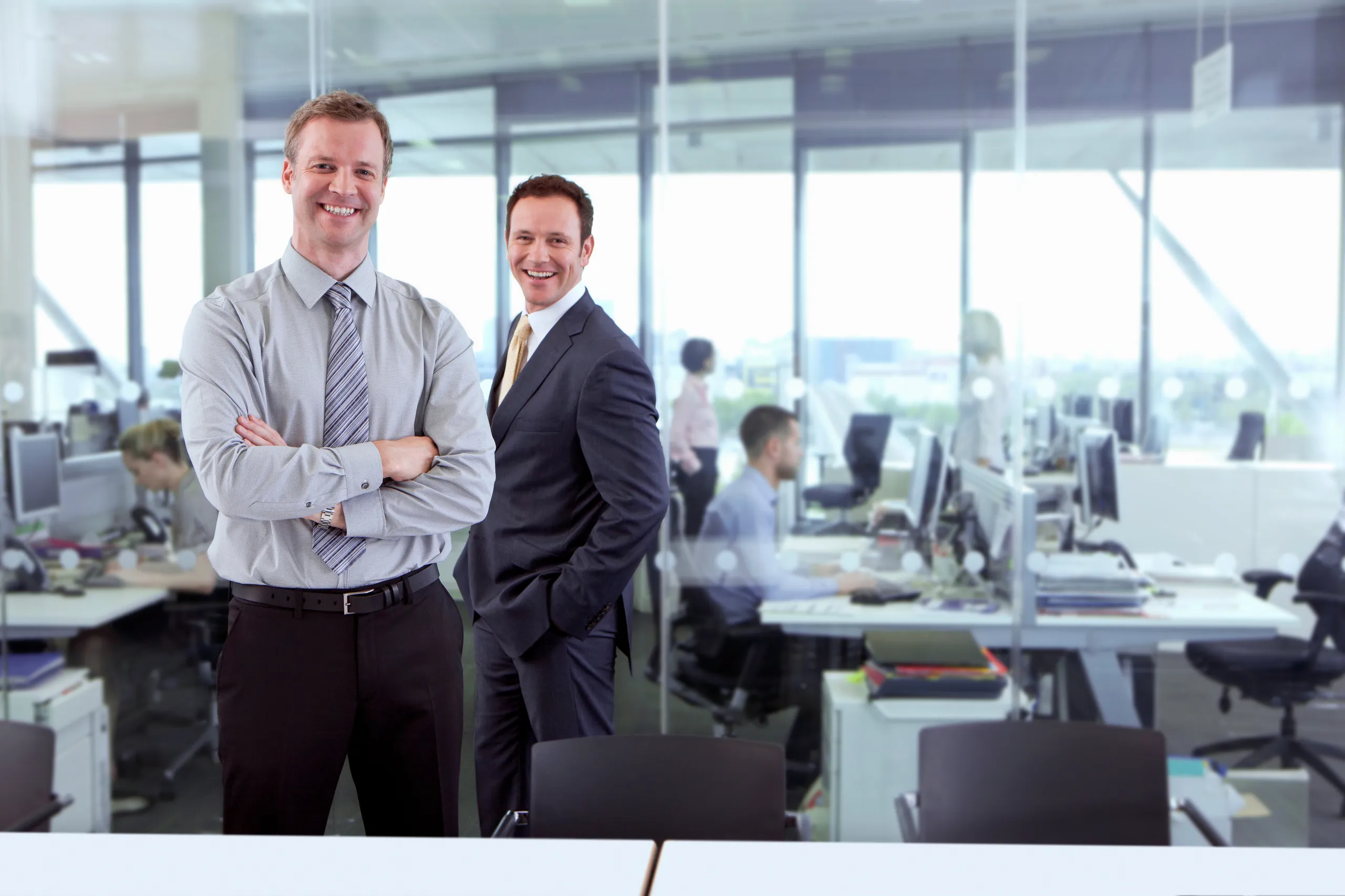 Fotográfia del jefe y subjefe de una empresa con cara de satisfacción al ver que la gestión organizacional de Ame Consultoría va por buen camino
